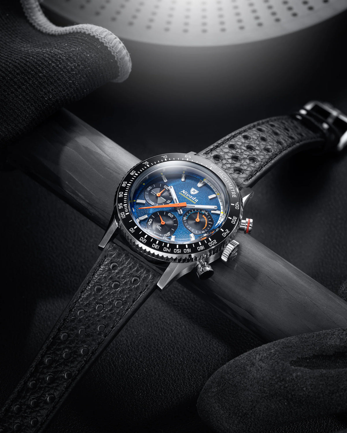 Nivada Grenchen Chronoking Mecaquartz Racing Blue with blue dial and perforated leather strap resting on a carbon tube